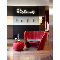 Table basse Blos rouge assortie avec un fauteuil rouage dans un restaurant italien design