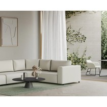 Canapé d'angle Teton blanc cassé dans un salon ouvert sur la terrasse, avec table basse noire et tapis vert