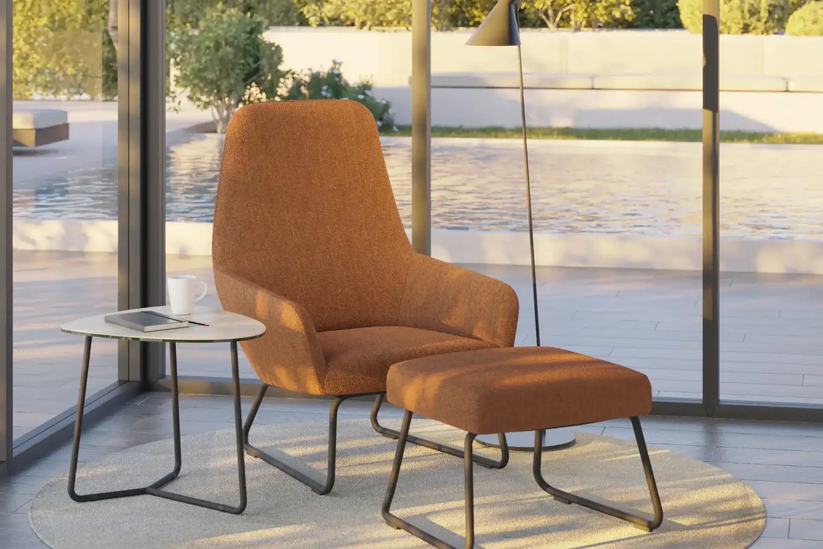 Fauteuil lounge Flux rouille et son repose-pieds assorti devant une baie vitrée