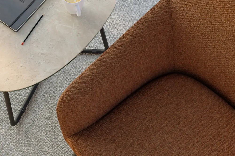 Gros plan sur le tissu rouille du fauteuil lounge Flux